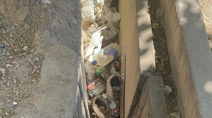 La acequia que está al lado de un hospital y está tapada de basura